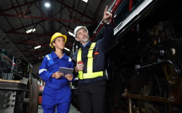Portrait of engineer and apprentice in workshop of railway engineering facility. Factory Portrait of engineer and apprentice in workshop of railway engineering facility. Factory